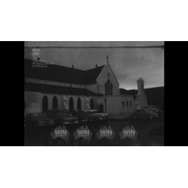 A priest blesses cars in a car park