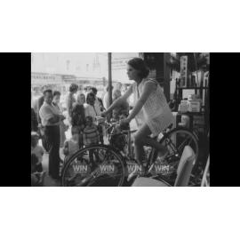 An underaged, hypnotised cyclist in a shop window