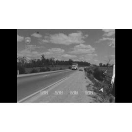 A truck carrying barrels has overturned and burned, killing its driver