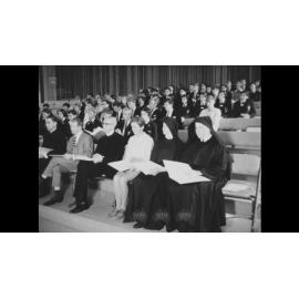A priest speaks to students and clerics