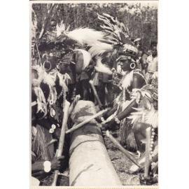 Children beating out dance rhythm on a hollow log